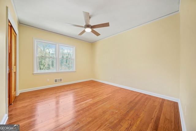 spare room featuring light hardwood / wood-style flooring, ceiling fan, and ornamental molding