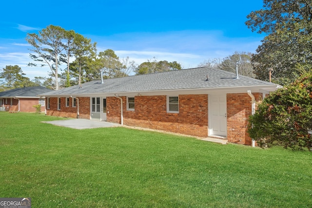 rear view of house with a yard and a patio