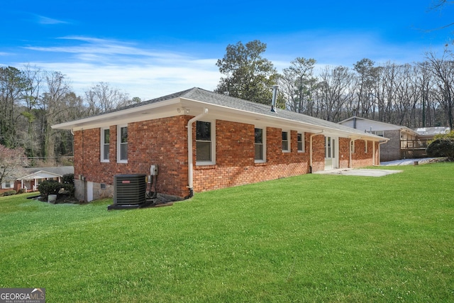 back of house with central AC unit and a lawn