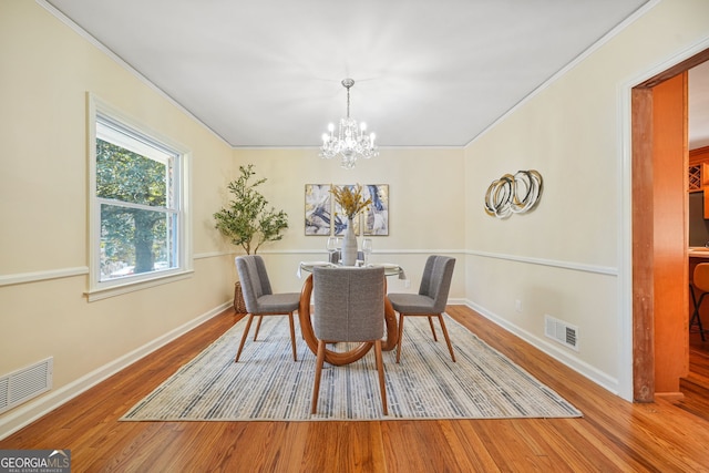 dining room featuring hardwood / wood-style floors, a notable chandelier, and crown molding