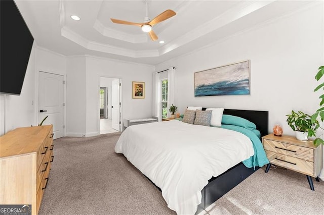 bedroom with a tray ceiling, ceiling fan, crown molding, and light colored carpet