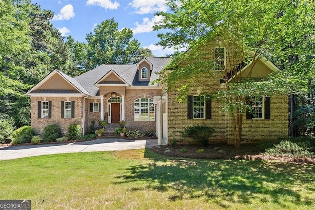 view of front of house with concrete driveway, brick siding, and a front yard