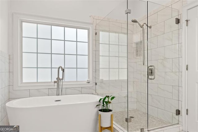 bathroom featuring plus walk in shower and tile walls