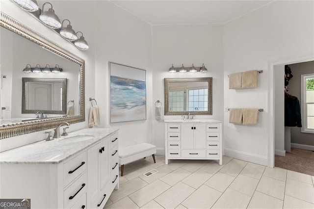 bathroom with a sink, two vanities, baseboards, and tile patterned floors