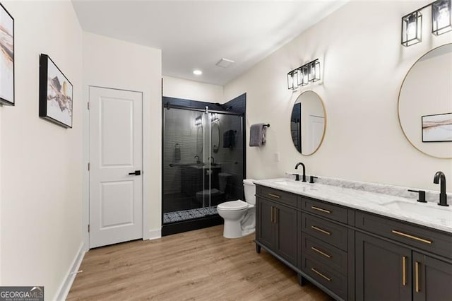 bathroom featuring a shower with shower door, toilet, wood-type flooring, and vanity