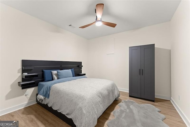 bedroom with ceiling fan and hardwood / wood-style flooring