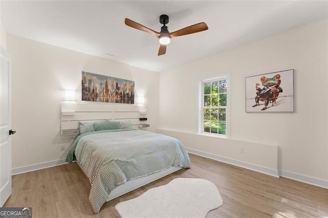 bedroom featuring baseboards, ceiling fan, and wood finished floors