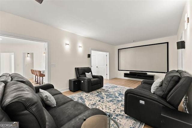 home theater featuring baseboards and light wood-style floors