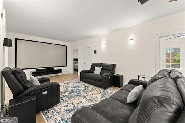 home theater with ceiling fan and light wood-type flooring