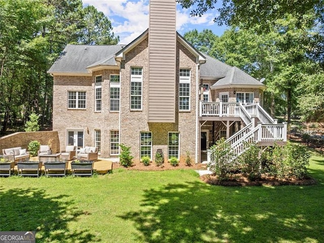 rear view of house with a deck, brick siding, a yard, stairway, and outdoor lounge area