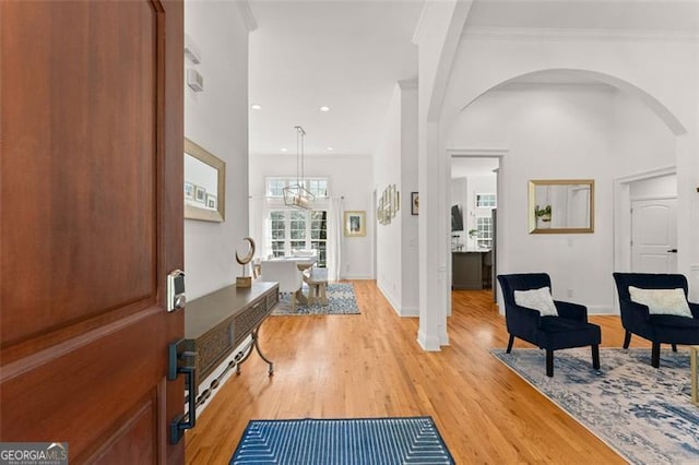 entryway featuring a chandelier, light wood-type flooring, and ornamental molding