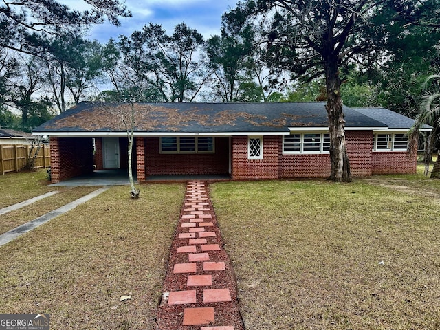 ranch-style house featuring a carport and a front lawn