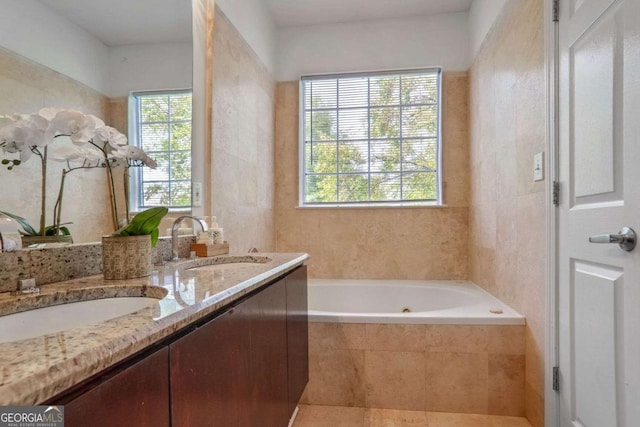 bathroom with tile patterned floors, tiled tub, vanity, and tile walls