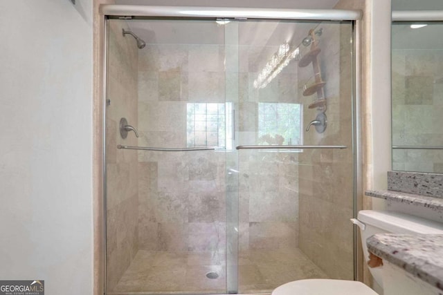 bathroom with toilet and an enclosed shower