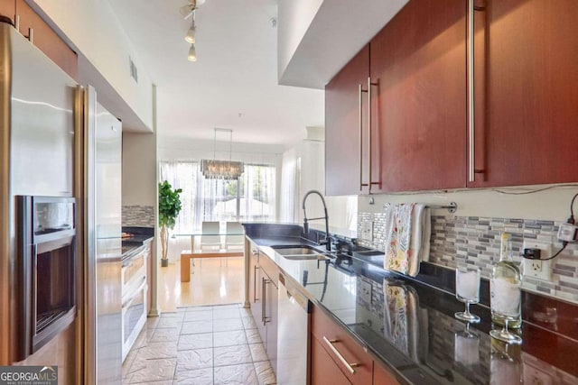 kitchen featuring dishwasher, sink, decorative light fixtures, stainless steel fridge with ice dispenser, and a chandelier