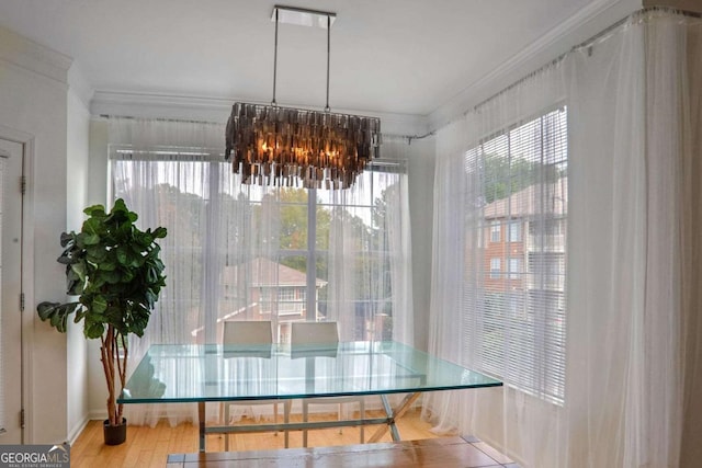 dining space with plenty of natural light, ornamental molding, and a notable chandelier