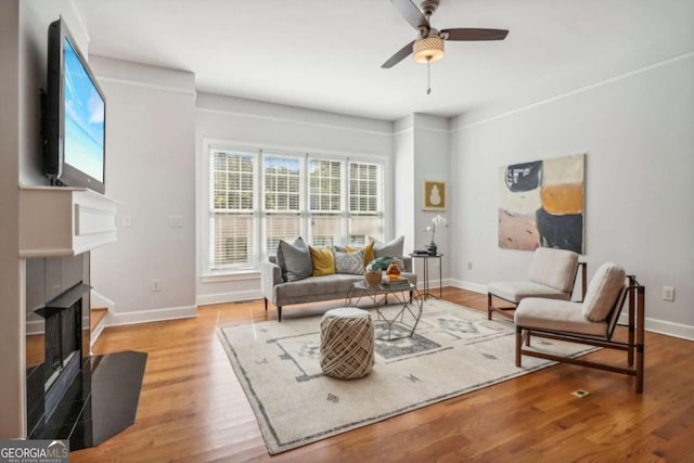 living room featuring ceiling fan and light hardwood / wood-style flooring