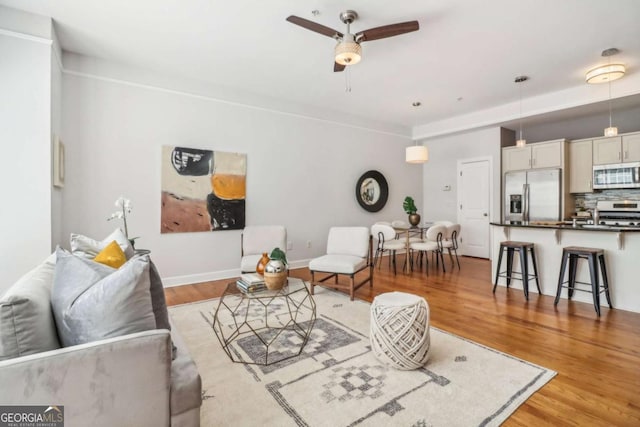 living room with ceiling fan and light hardwood / wood-style flooring