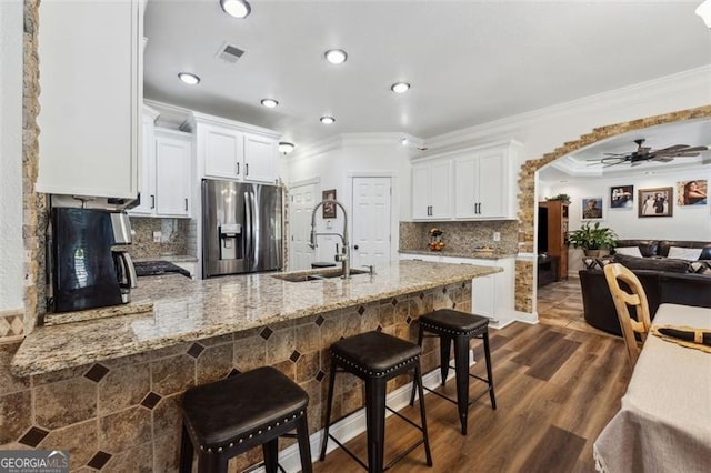 kitchen with ceiling fan, sink, white cabinetry, and stainless steel refrigerator with ice dispenser