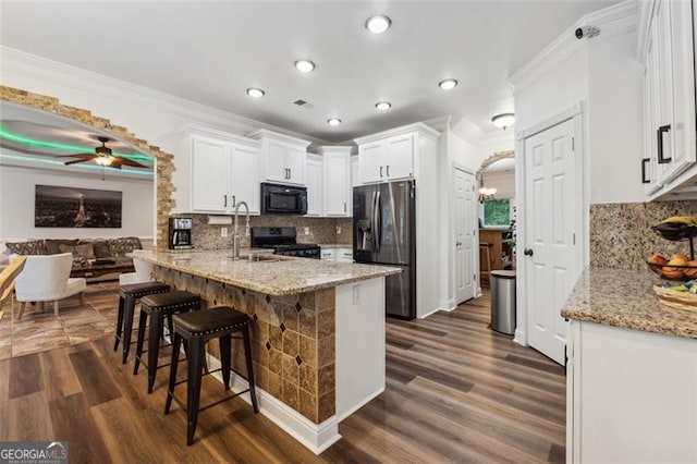 kitchen featuring black appliances, decorative backsplash, white cabinets, and kitchen peninsula