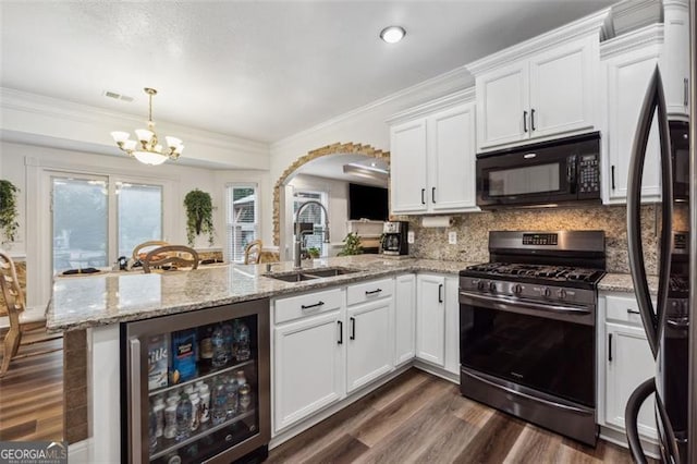 kitchen featuring white cabinetry, stainless steel appliances, wine cooler, backsplash, and kitchen peninsula