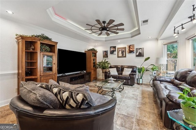 living room featuring a tray ceiling, ceiling fan, and ornamental molding