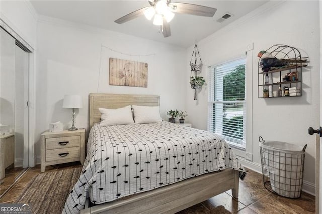 bedroom featuring ceiling fan, ornamental molding, and a closet