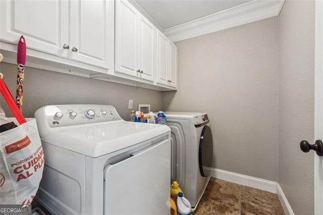 washroom featuring cabinets, washing machine and dryer, and ornamental molding