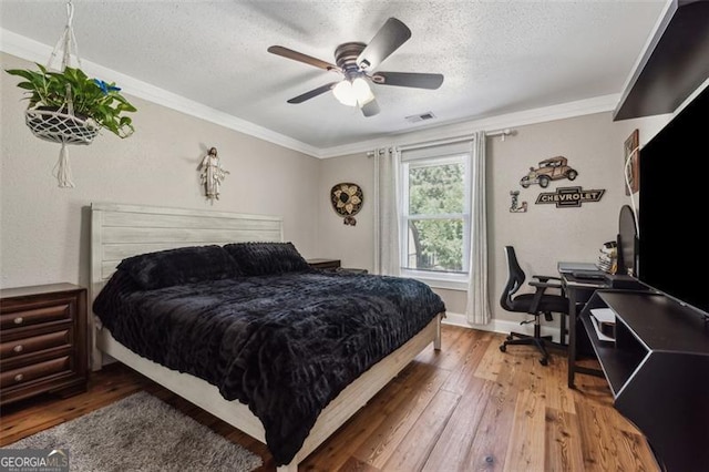 bedroom featuring hardwood / wood-style flooring, ceiling fan, and crown molding