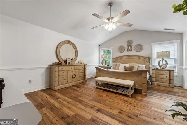 bedroom with ceiling fan, wood-type flooring, and vaulted ceiling