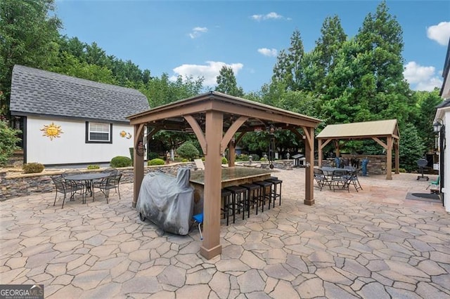 view of patio featuring a gazebo, area for grilling, and a bar