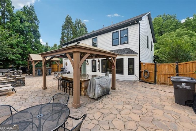 rear view of house with a gazebo, an outdoor bar, and a patio area