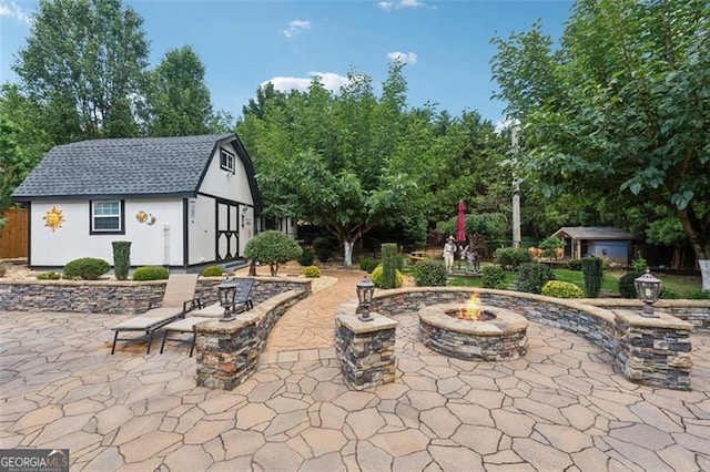 view of patio featuring an outdoor structure and an outdoor fire pit