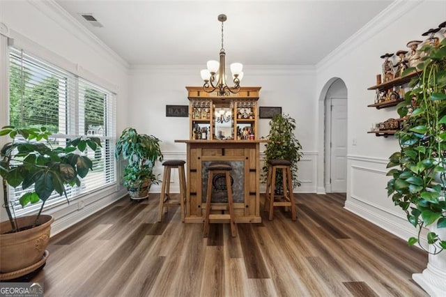 dining area with a chandelier, dark hardwood / wood-style floors, and ornamental molding