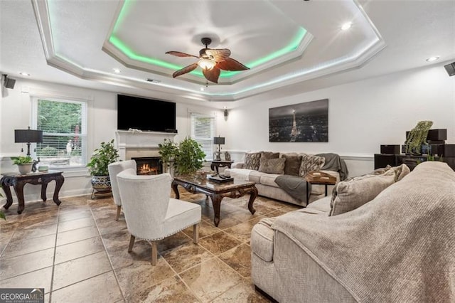 interior space featuring a raised ceiling and ceiling fan