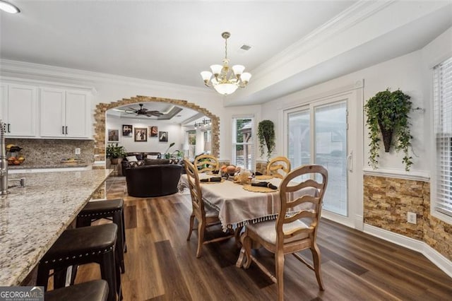 dining room featuring crown molding, dark hardwood / wood-style flooring, and ceiling fan with notable chandelier