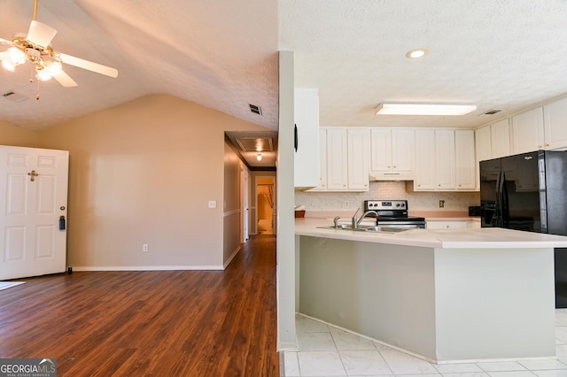 kitchen with stainless steel electric range, lofted ceiling, black refrigerator with ice dispenser, white cabinets, and kitchen peninsula