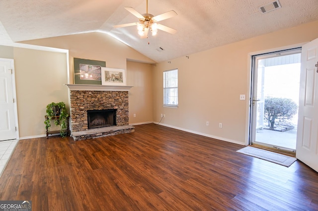 unfurnished living room featuring vaulted ceiling, dark hardwood / wood-style floors, ceiling fan, a textured ceiling, and a fireplace