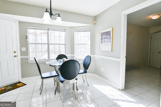 dining room with a chandelier and a textured ceiling