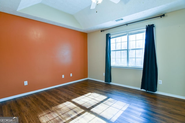 spare room with ceiling fan, dark wood-type flooring, a textured ceiling, and vaulted ceiling