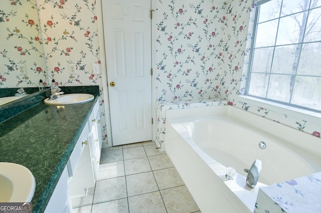 bathroom featuring a bathtub, tile patterned flooring, vanity, and a healthy amount of sunlight