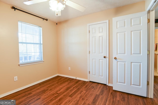 unfurnished bedroom with a textured ceiling, ceiling fan, and dark hardwood / wood-style floors