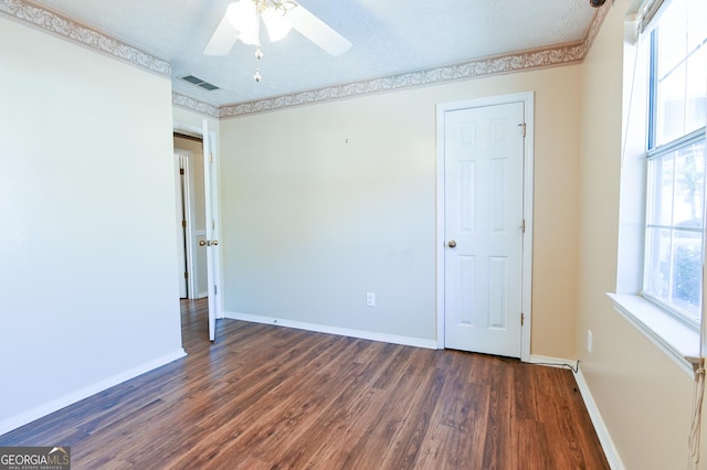 empty room featuring a textured ceiling, ceiling fan, and dark wood-type flooring