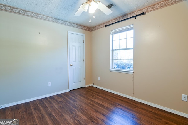 empty room with a textured ceiling, dark hardwood / wood-style floors, and ceiling fan