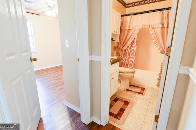 full bathroom with hardwood / wood-style floors, vanity, shower / bath combo, ceiling fan, and toilet