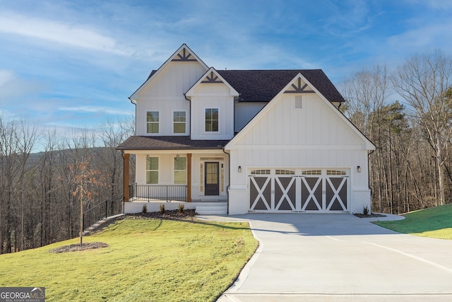 view of front of home featuring covered porch, a front yard, and a garage