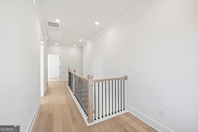 hallway featuring light wood-type flooring and crown molding