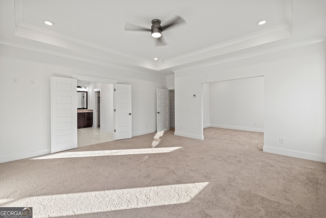 unfurnished bedroom with a tray ceiling, ceiling fan, and ornamental molding