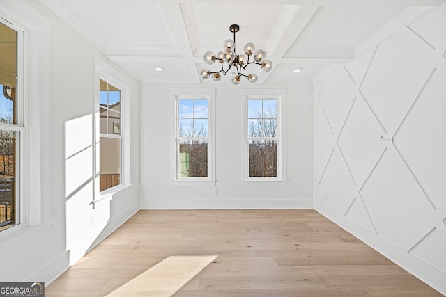 unfurnished dining area with beamed ceiling, a notable chandelier, light hardwood / wood-style floors, and coffered ceiling