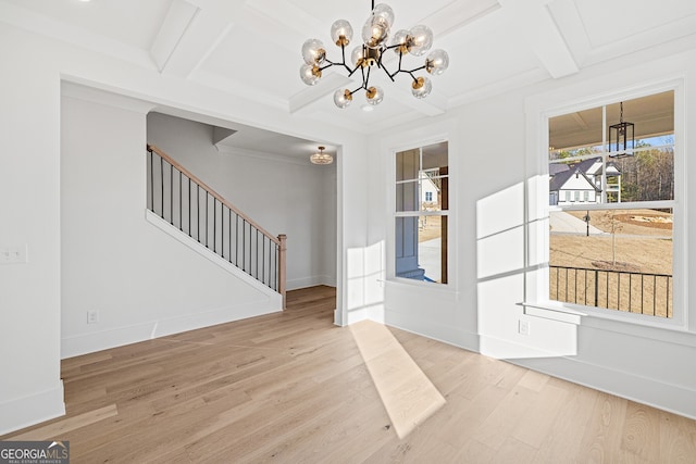 foyer entrance with light hardwood / wood-style flooring, beamed ceiling, a chandelier, and coffered ceiling